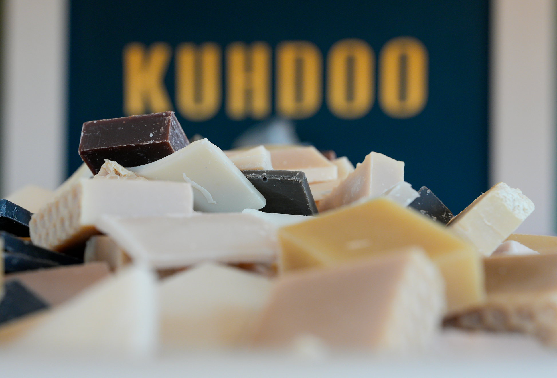 Assorted bars of soap with 'KUHDOO' branding in the background